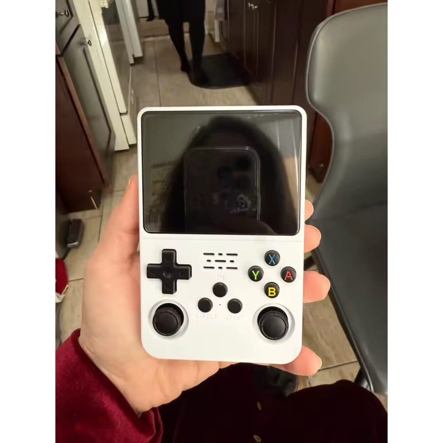 Consola portátil retro blanca sostenida en la mano